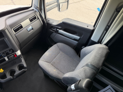 Kenworth T680 truck cabin interior with steering wheel, gray fabric seats, and dashboard controls visible.