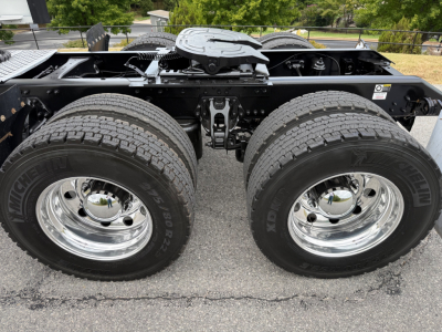 Kenworth T680 chassis showing dual rear axles and wheels with chrome rims and tires, frame rails and fifth wheel area visible.