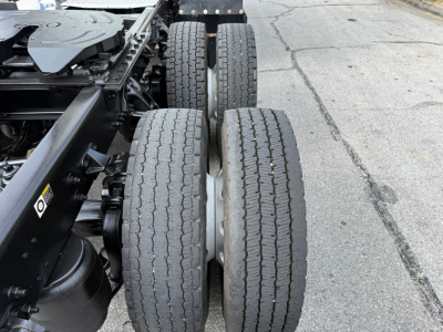 Kenworth T680 chassis showing dual rear axles and tires with tread, side view of drivetrain and frame.