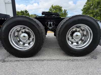 Twin rear wheels of a 2023 Kenworth T680 truck showing chrome rims and dual tires with a center height clearance. VIN 1XKYD49XXPJ268609 stock 0629621.
