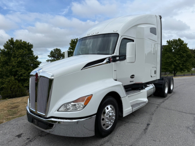 Kenworth T680 tractor in white, convention sleeper, front-left view with chrome grille, cab mirrors, and dual rear axles.