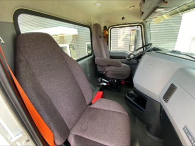 Truck cab interior of a 2021 Mack AN64T showing driver seat, steering wheel, dashboard, and passenger seat.