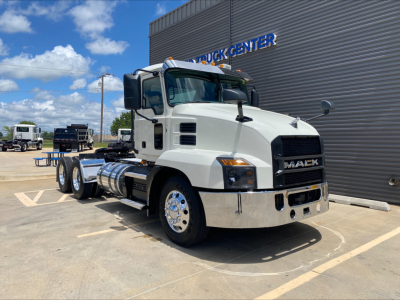 White 2021 Mack AN64T conventional day cab truck parked outside a building with chrome bumper and dual rear axles.