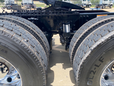 Mack AN64T conventional daycab chassis showing dual rear axles, suspension, and frame with visible tires and wheel hubs.