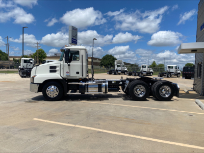 Truck chassis with cab on left, Mack AN64T spec outline, foreground shows side view of conventional daycab truck with dual rear axles and chrome fuel tanks.