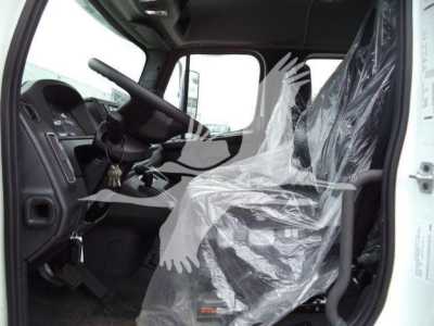 Truck cab interior showing steering wheel and driver seat covered in plastic wrap.