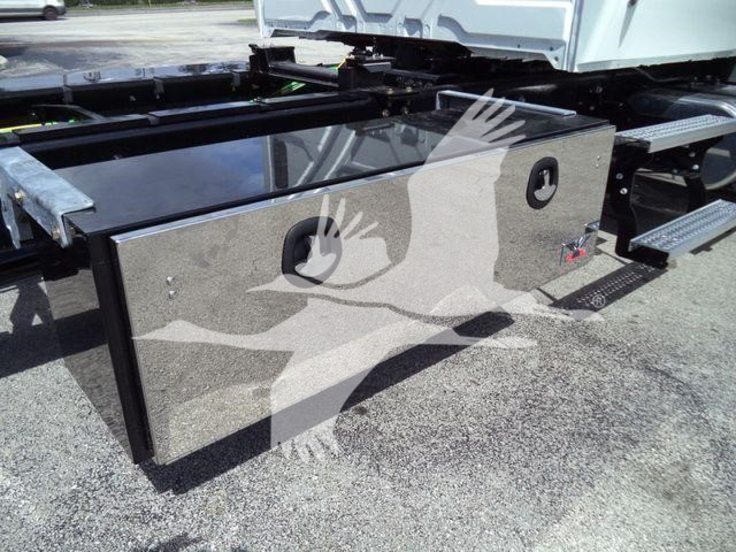 Battery box/storage box mounted on truck frame with polished metal surface and circular access panels