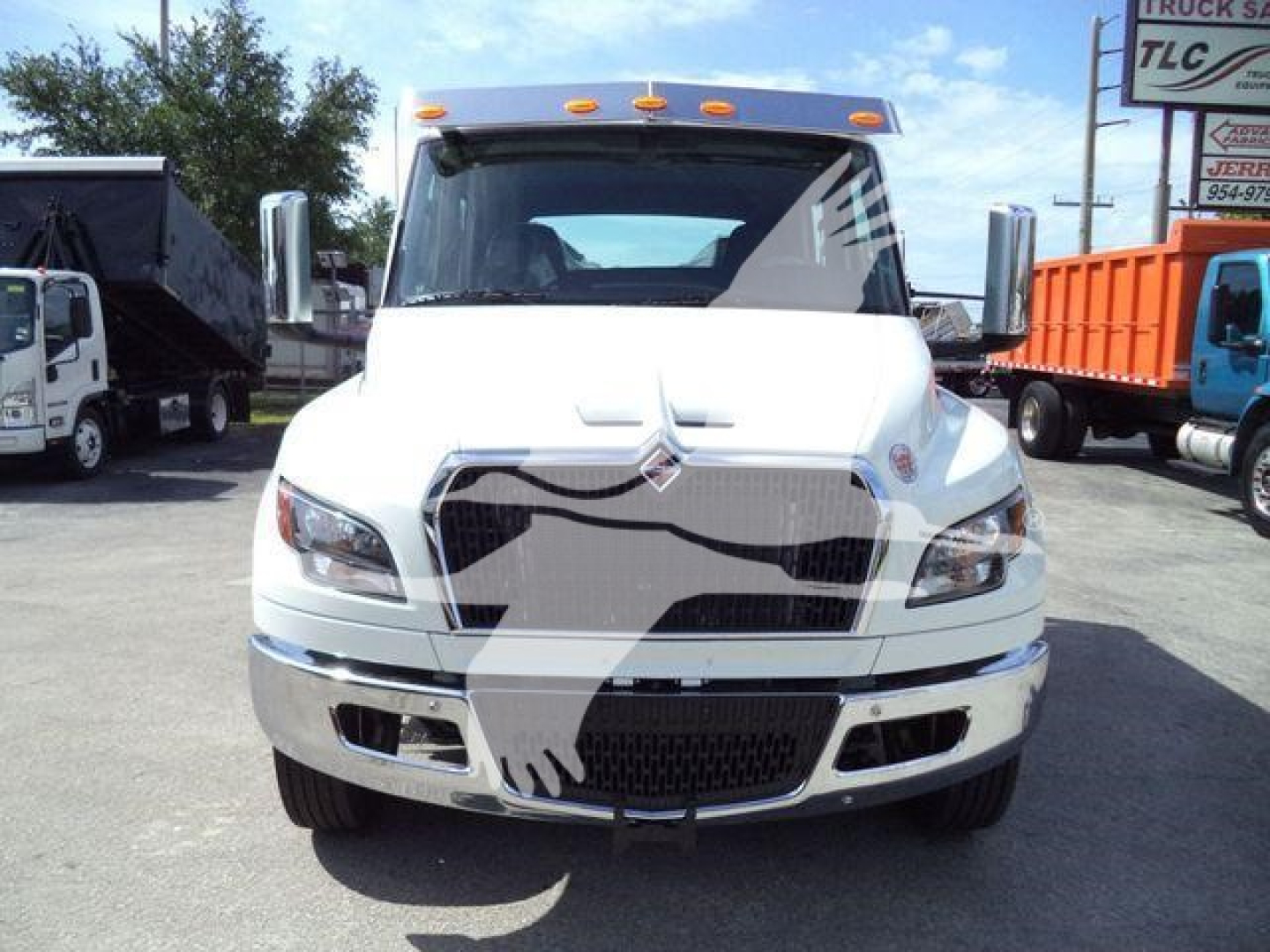 Truck front view of a white International MV with grille and headlights visible in a dealership lot.