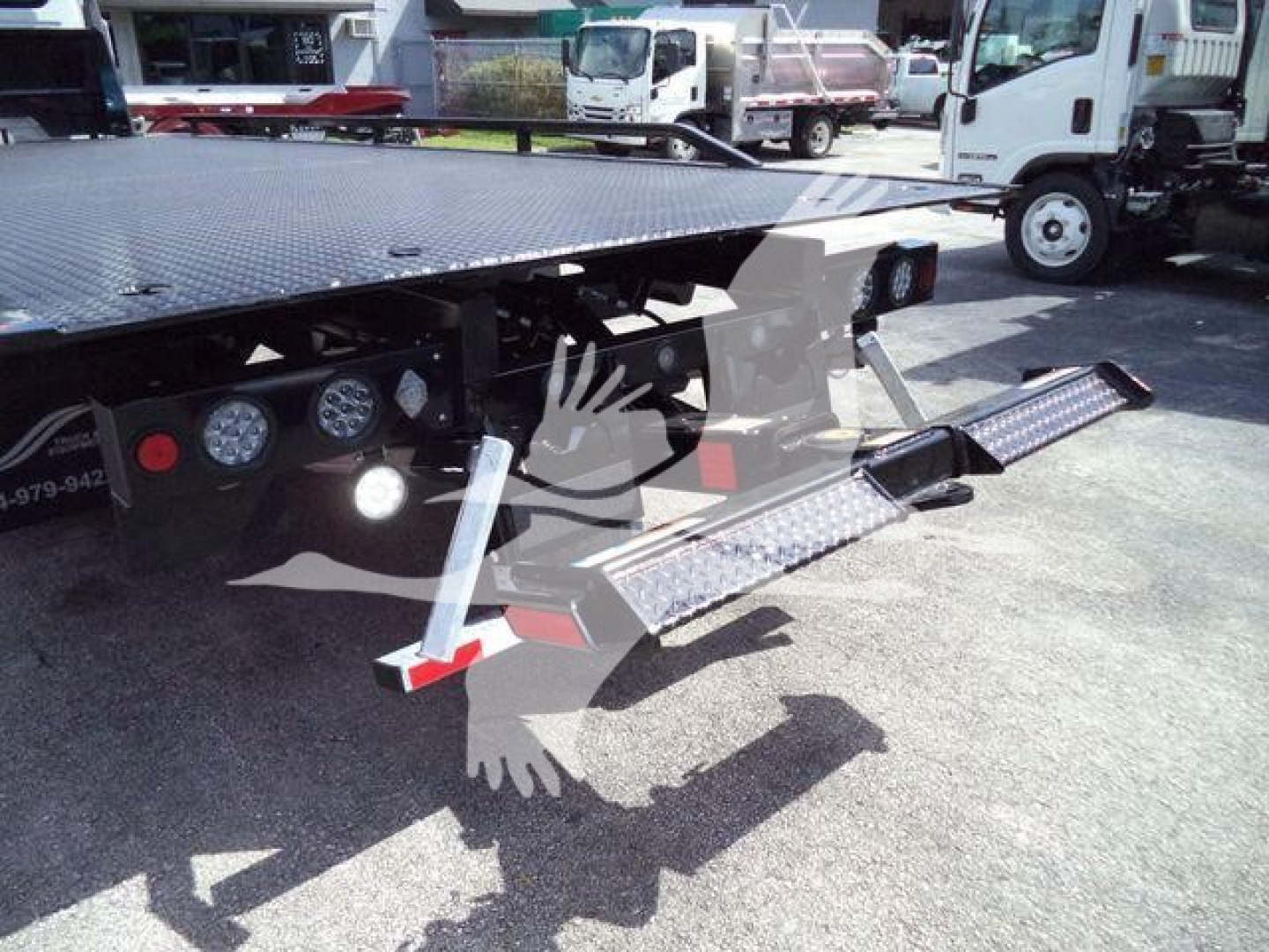Truck tow/rollback flatbed with folding steel ramps and diamond plate surface.