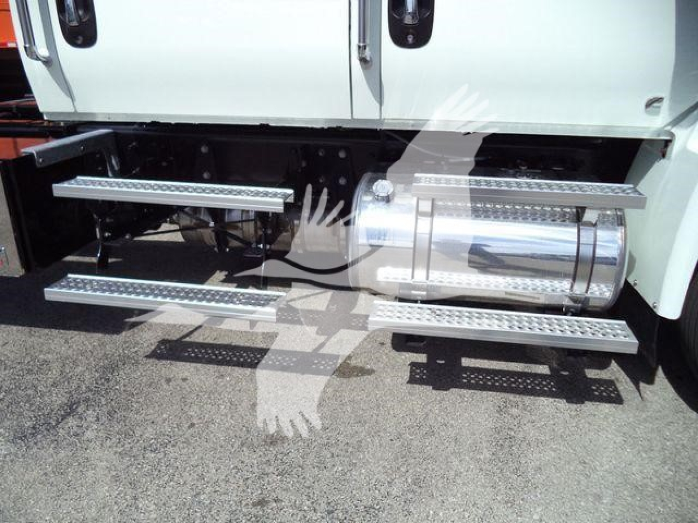 Truck side steps and fuel tank on the passenger side of a white International MV, showing chrome running boards and a polished cylindrical fuel tank.