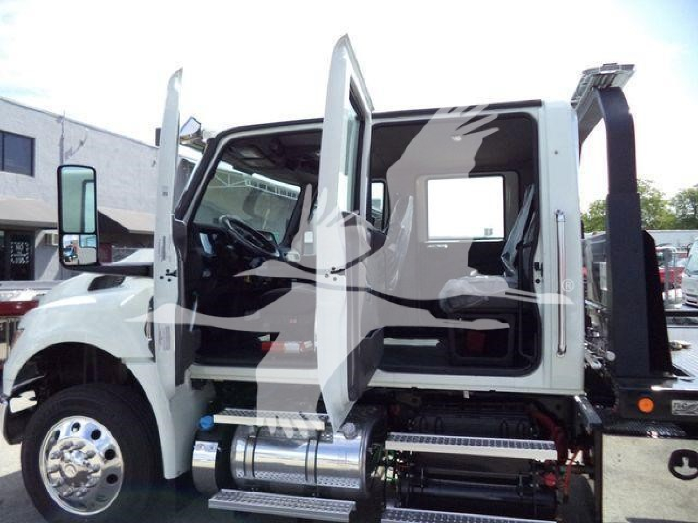 Truck cab doors open showing interior and chrome fuel tanks with side steps