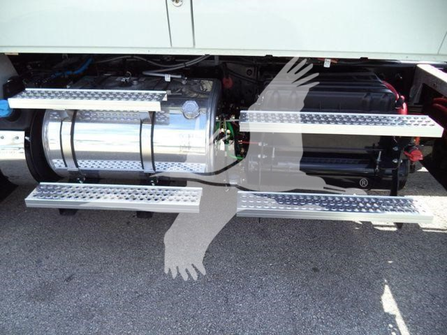 Truck side view showing fuel tank and auxiliary power unit under a cab with aluminum running boards and steps.