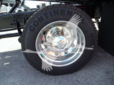 Truck wheel with Continental tire and polished chrome hub showing axles and suspension components.