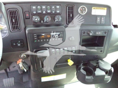 Dashboard view of a 2026 International MV interior showing controls, vents, gauges, cup holder, and radio area.