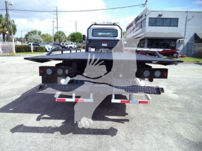 Flatbed tow truck trailer rear view showing platform and ramps with taillights and reflective strips.