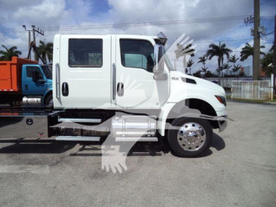 Side view of a white International MV truck with a crew cab, showing the front wheel and chrome fuel tank, no visible text legible on the cab.