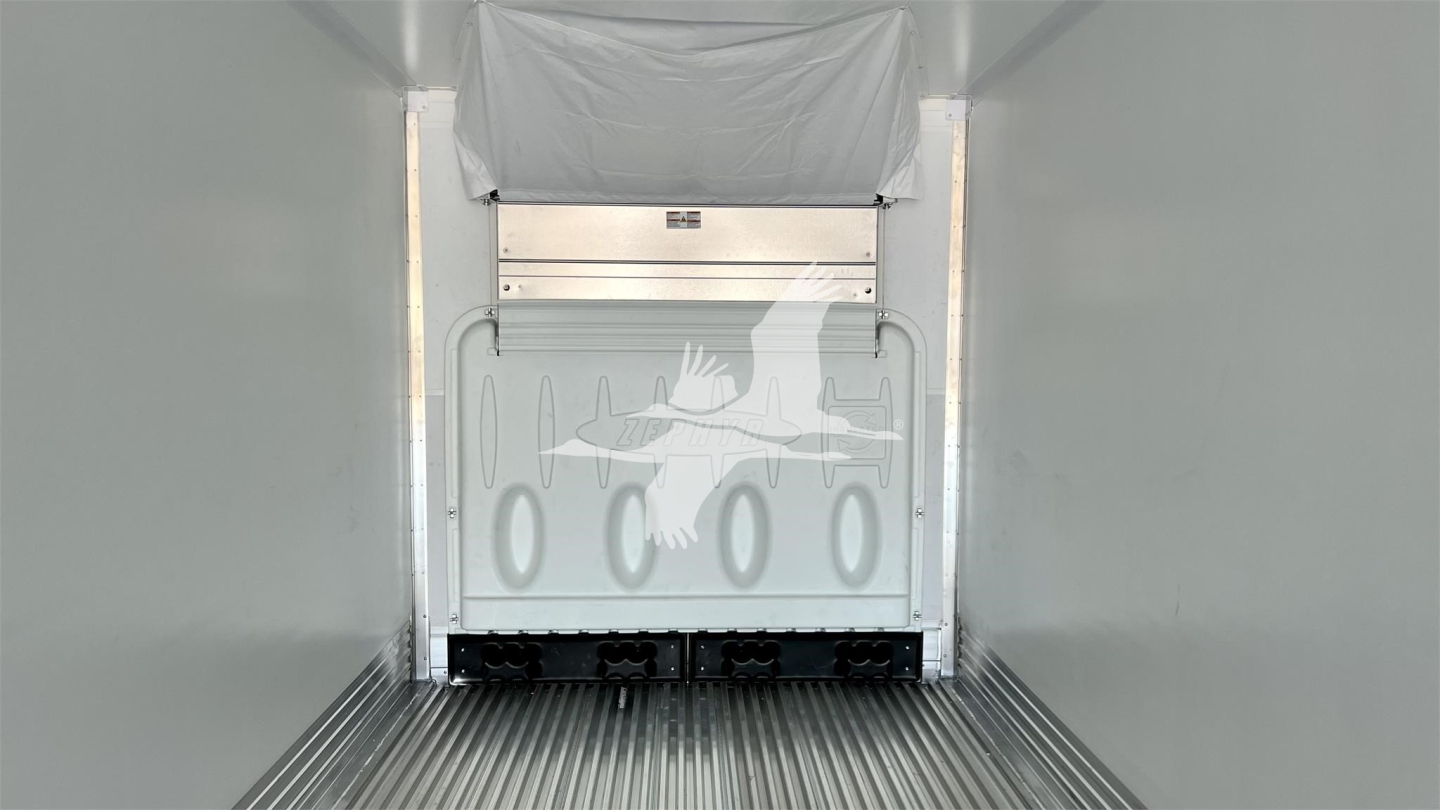 Reefer trailer interior showing rear door and metal floor with ribbed texture.