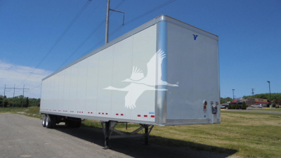 Trailer in a parking lot showing a white goose graphic on the side and rear, lightweight cargo trailer with tandem axles and hitch, blue sky.