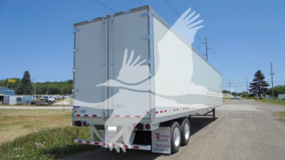 Rear and side view of a Vanguard VXP trailer with white exterior, double rear doors, and safety decals on the lower rear; no legible branding text visible.