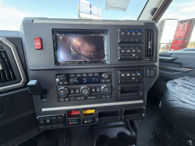 Dashboard of a new Mack PR64T76H sleeper cab showing touchscreen infotainment, climate controls, and multiple switches.