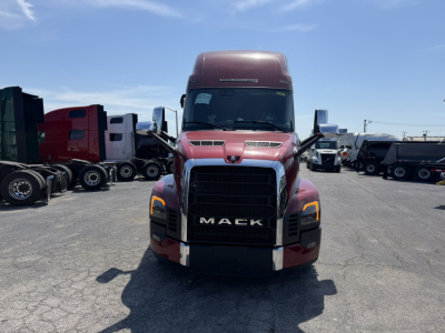 Mack PR64T76H conventional sleeper truck front view showing bold black grille with MAC K lettering, maroon cab, large bumper, daytime running lights.