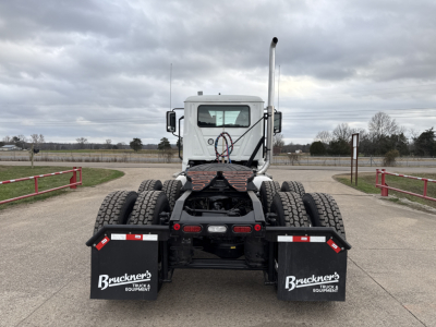 Truck chassis back view of a new Mack PI64T conventional daycab showing dual rear axles and mud flaps with Brückner's Equipment logos.