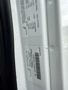 Label stickers on Mack PI64T door jamb with VIN/barcode and manufacturer information.