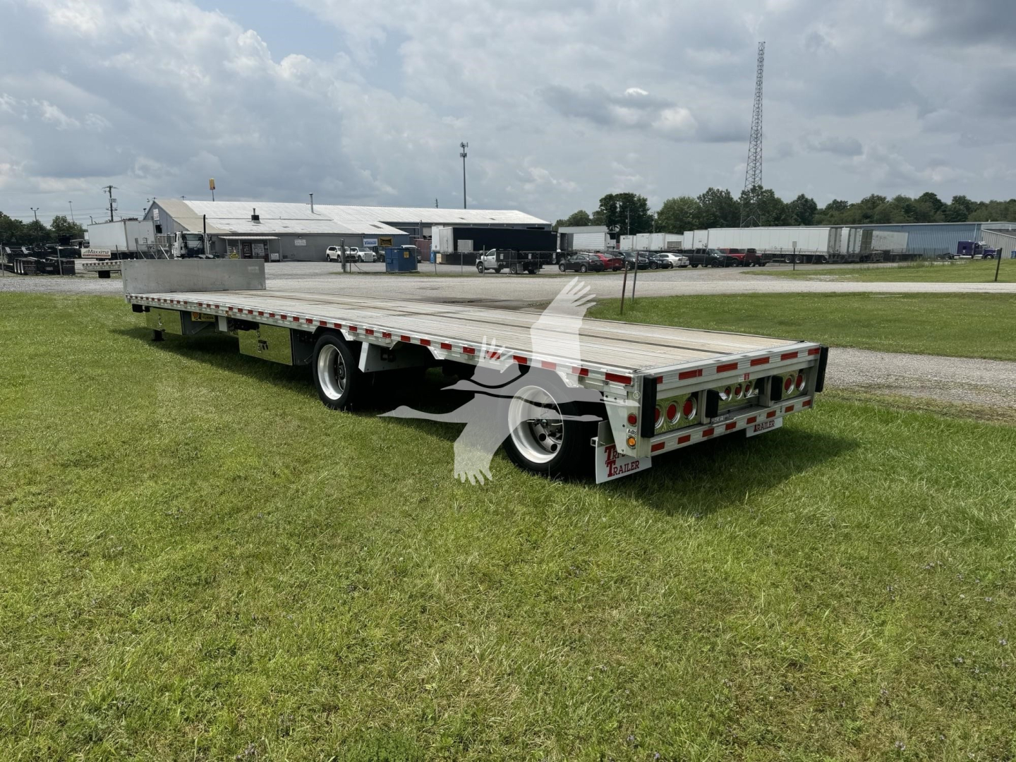 Flatbed trailer in service view showing drop deck with Ras air suspension and rear lights.