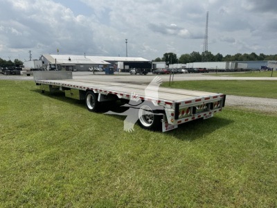 Flatbed trailer in service view showing drop deck with Ras air suspension and rear lights.