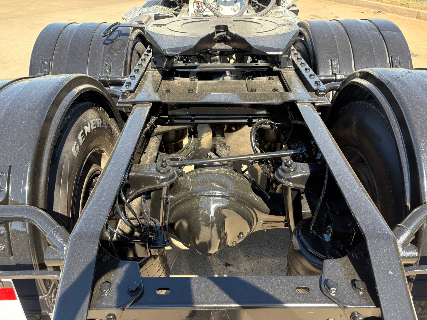 Kenworth T880 rear drivetrain with dual axles and fifth-wheel mounting showing suspension and driveline components.