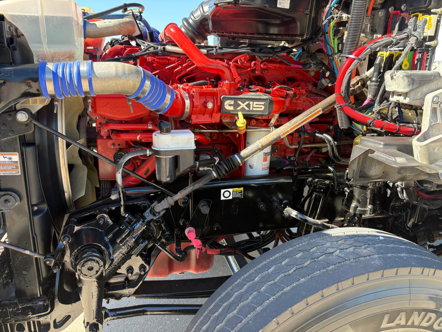 Kenworth T880 engine bay showing Cummins X15 engine and surrounding hoses and components.