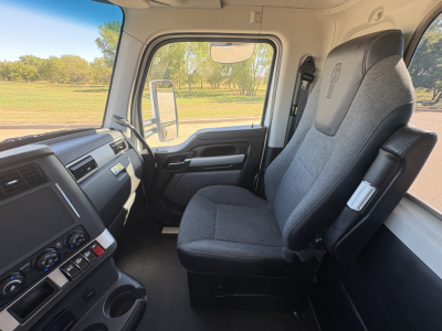 Kenworth T880 truck cab interior showing driver and passenger seats with dashboard controls and steering wheel visible.