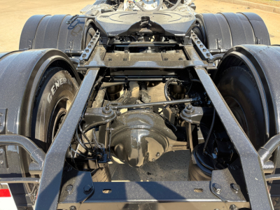 Kenworth T880 rear drivetrain with dual axles and fifth-wheel mounting showing suspension and driveline components.