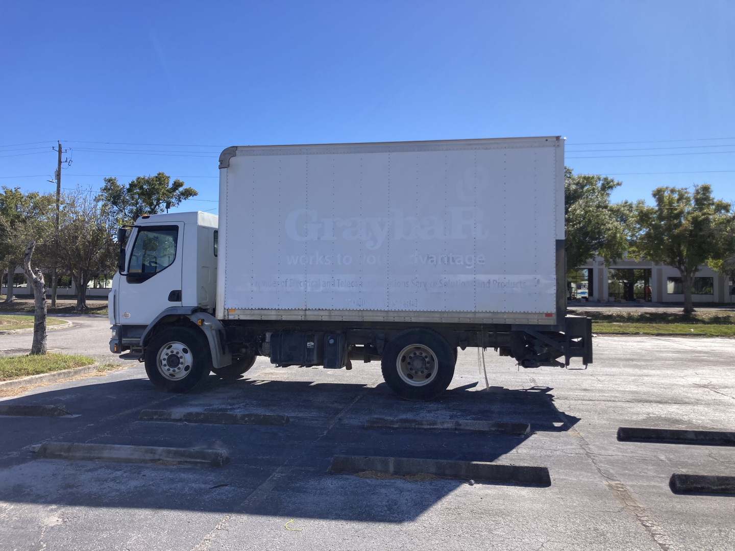 Vehicular side view of a white 2017 Peterbilt 220 box truck with a large cargo box; faint text on the box reads 'Gra...'