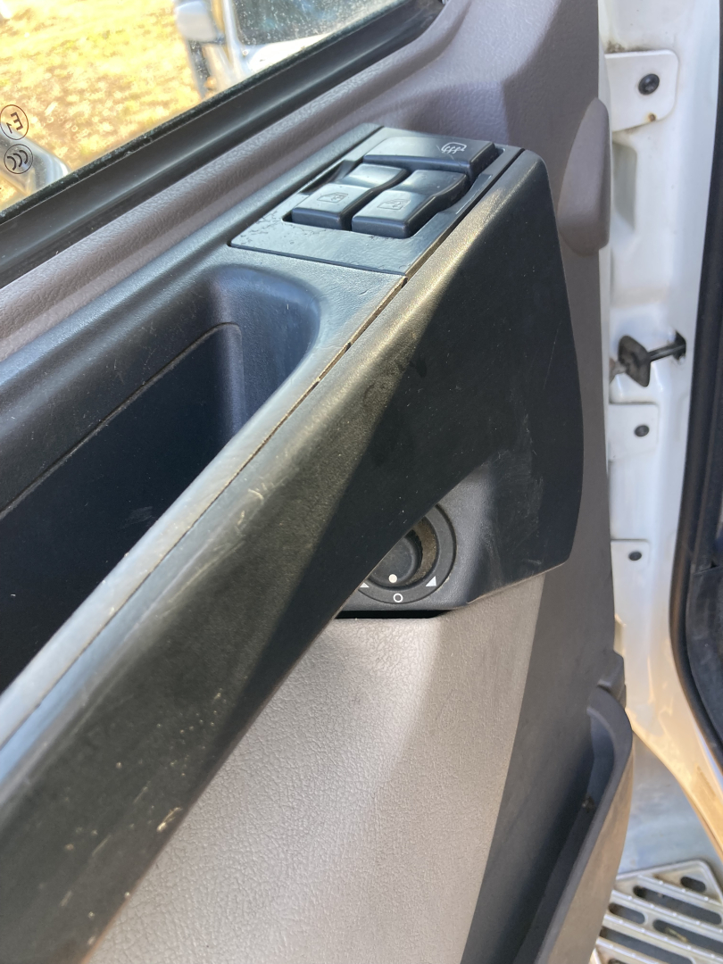 Peterbilt 220 cab interior door panel showing window/lock controls and door edge with window frame.