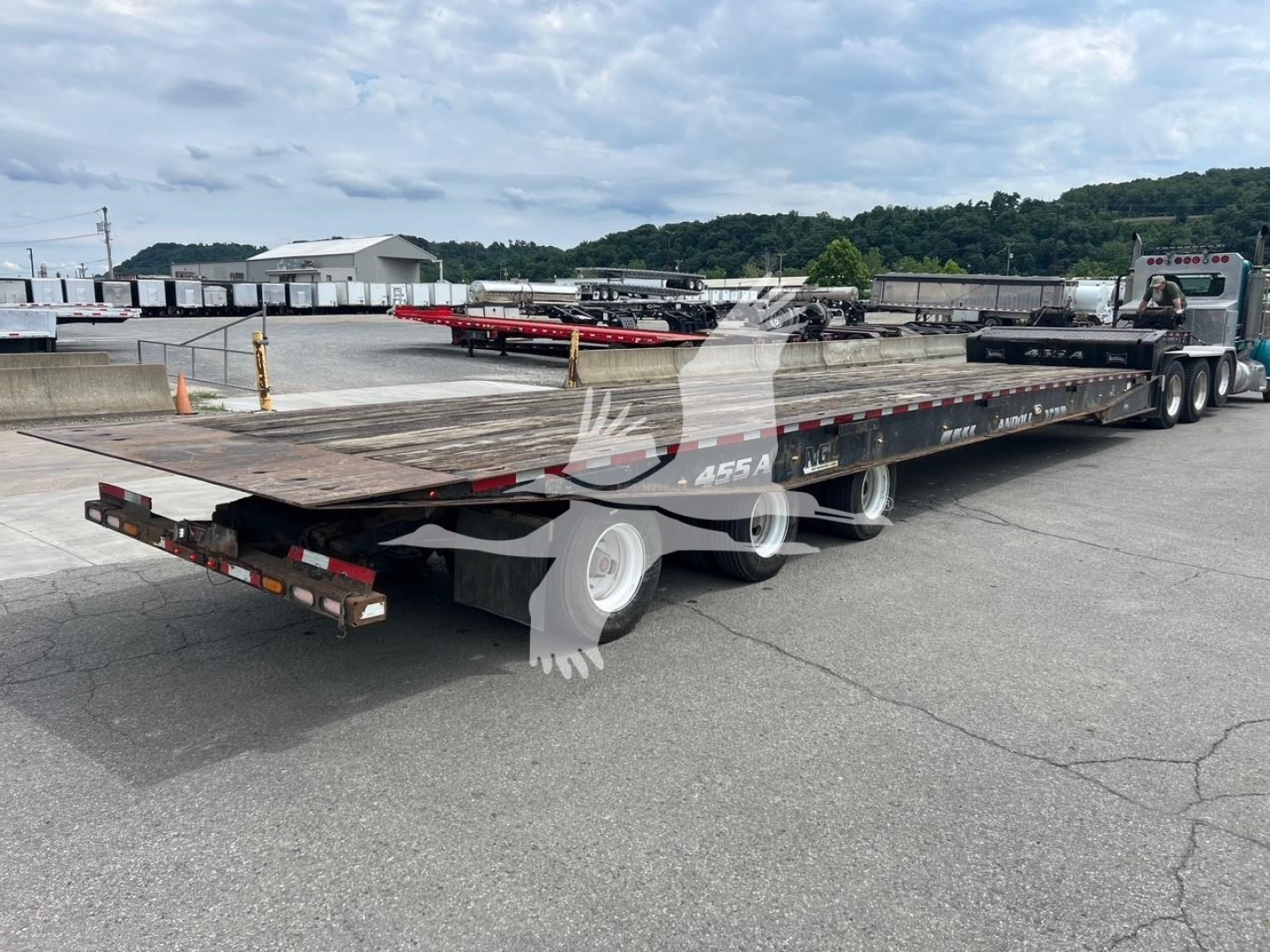 Trailer showing a Landoll 455A-53 lowboy with a long deck and multiple axles, flatbed surface, semi-truck in background, stock number 7531 visible.