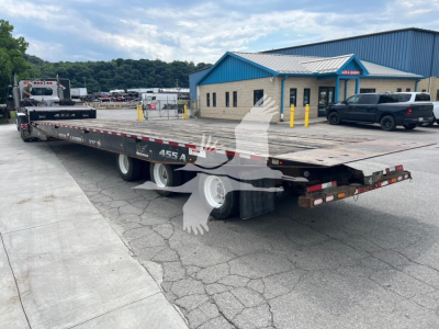 Landoll 455A-53 trailer in a parking lot showing long flatbed with dual rear axles and ramp at back.