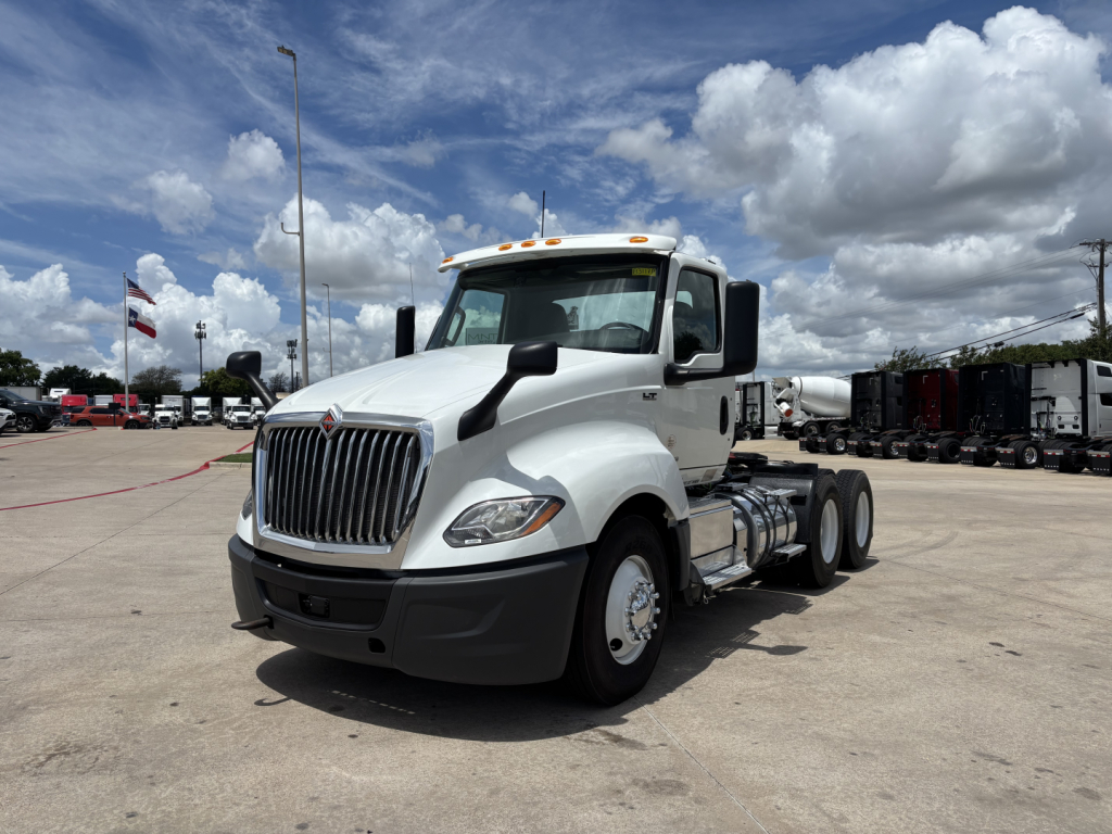 Truck cab of a white 2019 International LT daycab with front grille and dual rear axles, parked in lot.