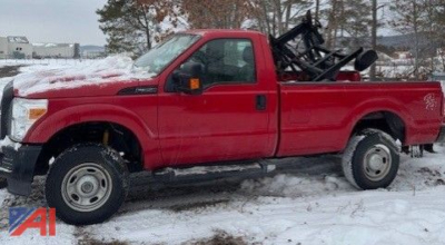 Ford F-350 Super Duty pickup with plow attachment in red, side view in snow.