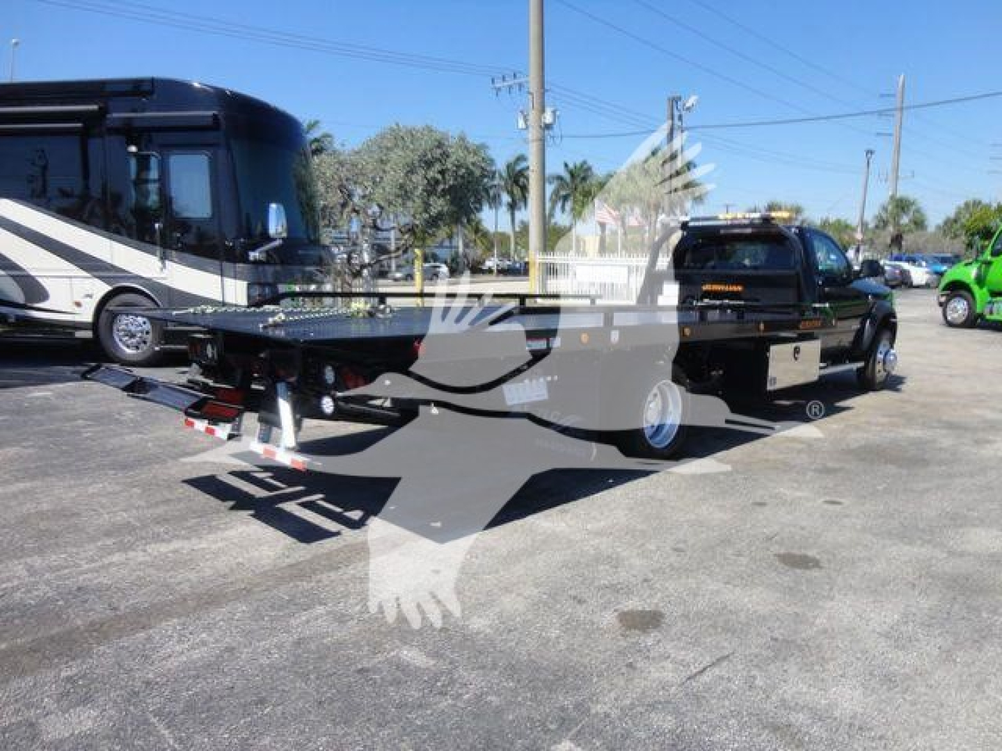 Ram 5500 SLT rollback tow truck viewing rear/side showing flatbed equipment and tow setup.