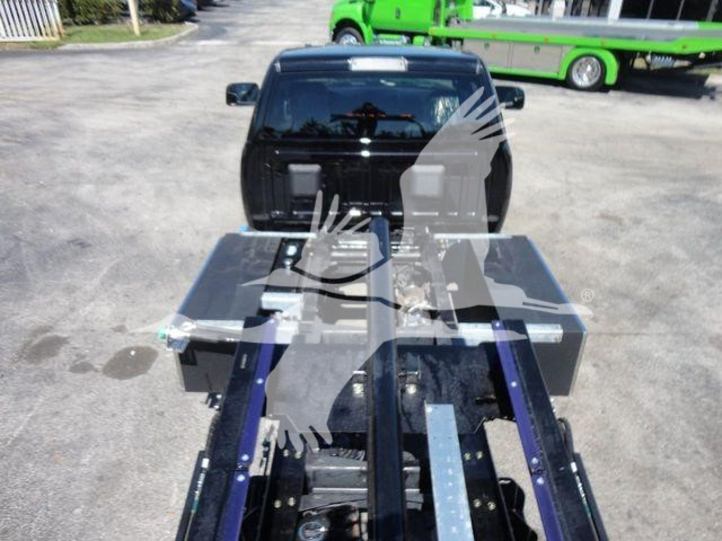 Ram 5500 rollback truck with a flatbed and storage boxes visible in the bed; stock number J24797; rolling tow truck equipment in foreground.