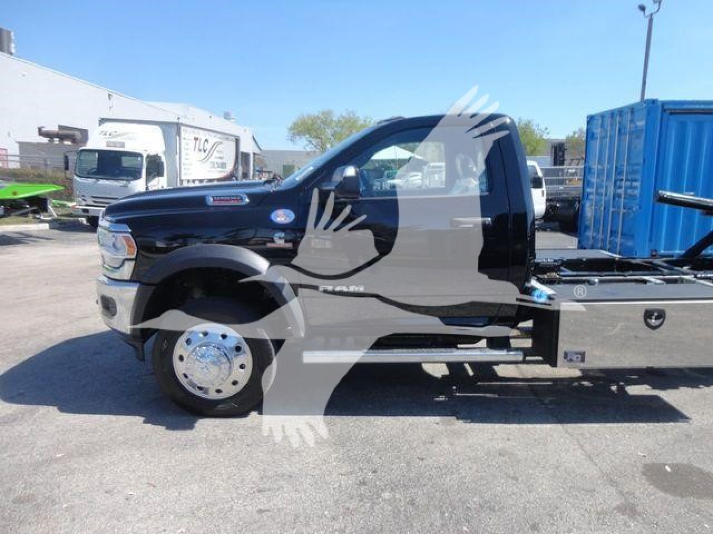 Ram 5500 rollback truck side profile showing black cab and flatbed with chrome front wheel and side step, stock number J24797