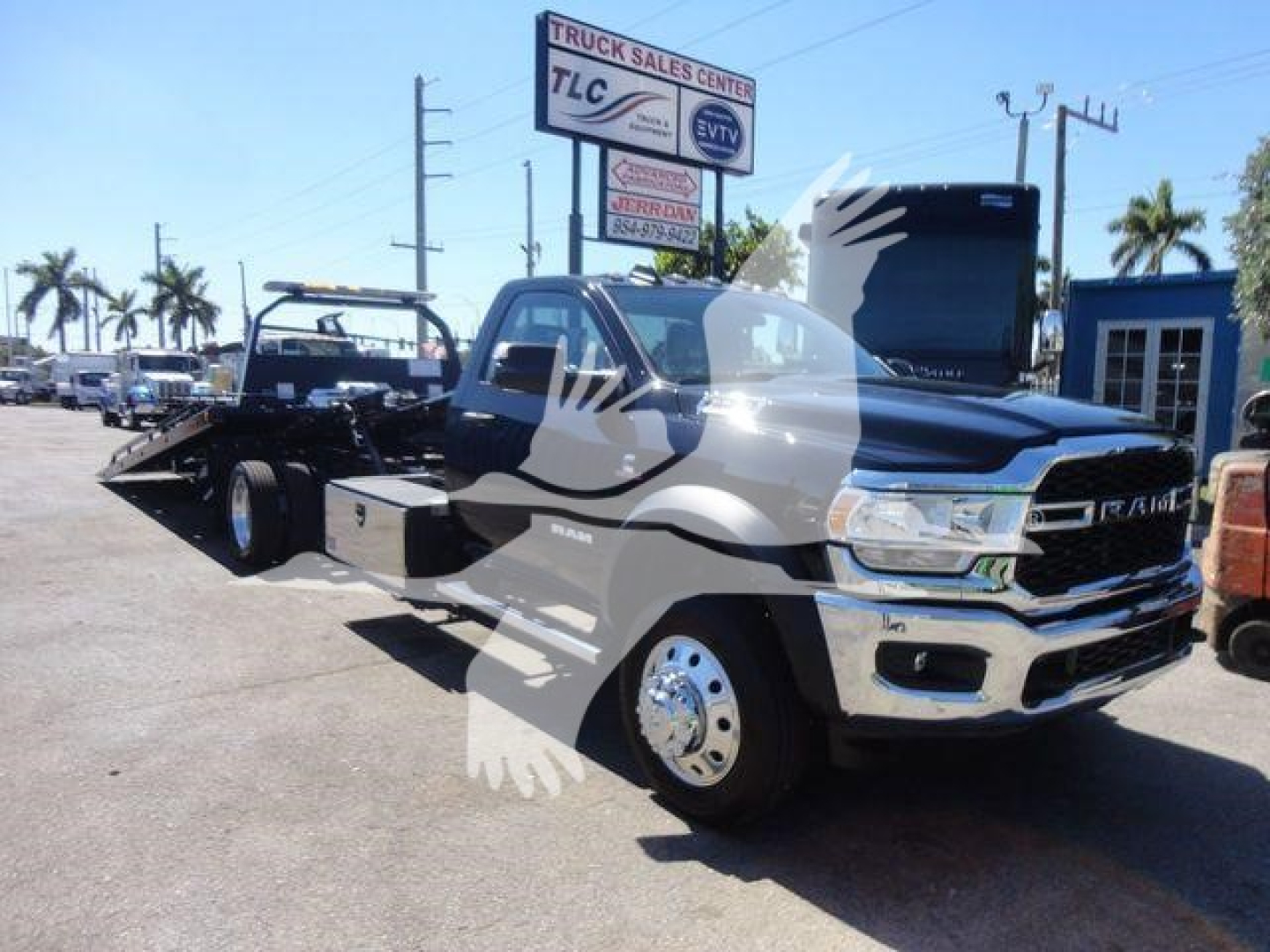 2024 Ram 5500 SLT rollback truck in dealership lot, front three-quarter view showing cab and flatbed chassis, chrome front grille, RAM badge, LED headlights