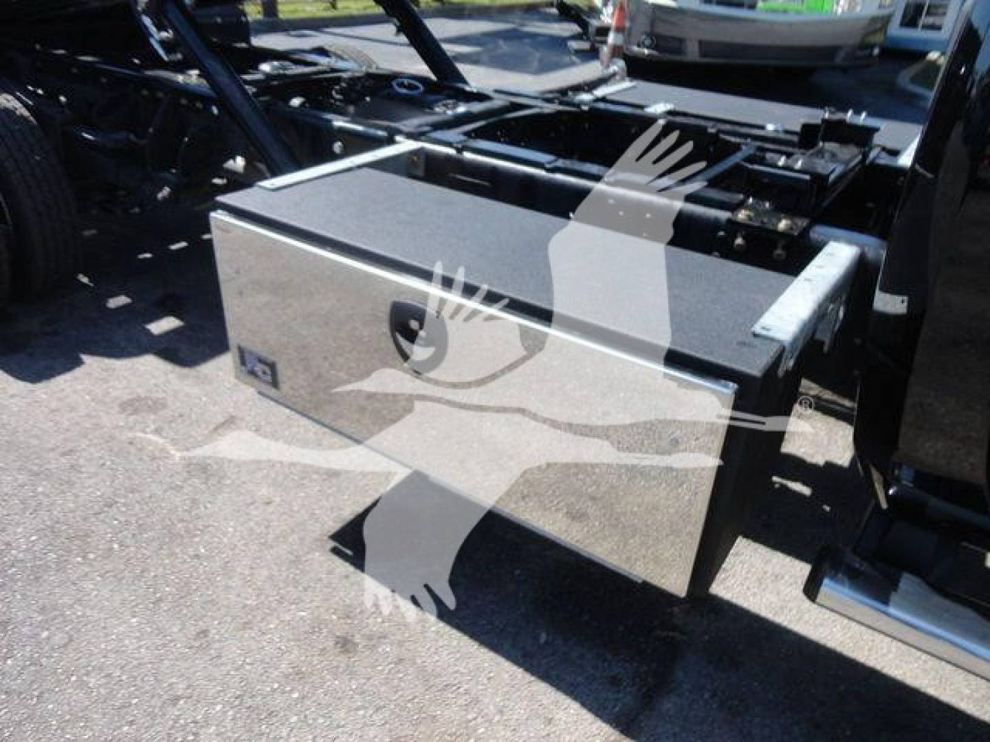 Truck bed toolbox on Ram 5500 rollback chassis showing metal storage box attached to frame.