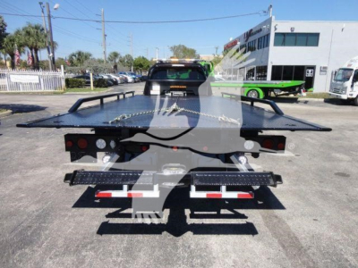 Ram 5500 rollback tow truck flatbed showing rear view with dual tow platforms and hydraulic bed, license plate area, and rear lights.