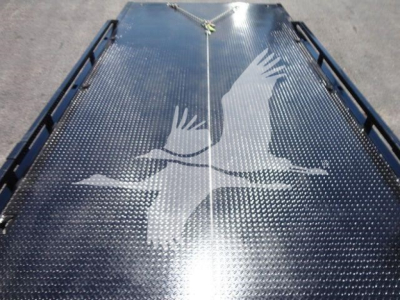 Ram 5500 rollback truck bed with eagle wing graphic on diamond plate surface.