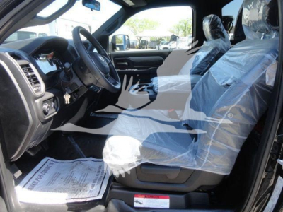 Ram 5500 SLT interior with protective plastic on seats, steering wheel, and front console; driver-side view showing dashboard and seating.