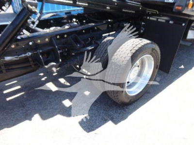 Truck rear wheel and undercarriage of a 2024 Ram 5500 SLT rollback truck showing dual rear wheels and chassis components.