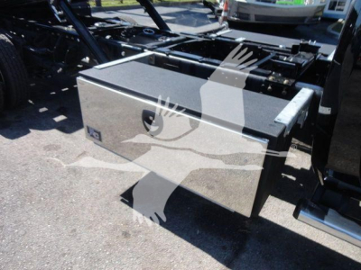 Truck bed toolbox on Ram 5500 rollback chassis showing metal storage box attached to frame.
