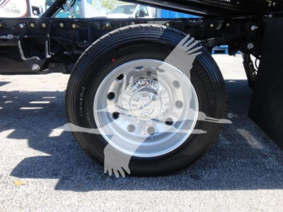 Truck wheel close-up showing steel rim and tire on Ram 5500 chassis component; visible are tire treads and wheel hub with lug nuts.